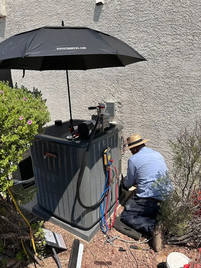 HVAC technician performing outdoor AC maintenance in Williamson